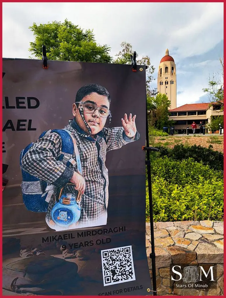 A portrait of Mikaeil Mirdoraghi, a 9-year-old boy, is displayed at the Stanford University Minab vigil, with Hoover Tower in the background